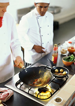 high angle view of two chefs cooking food in the kitchen